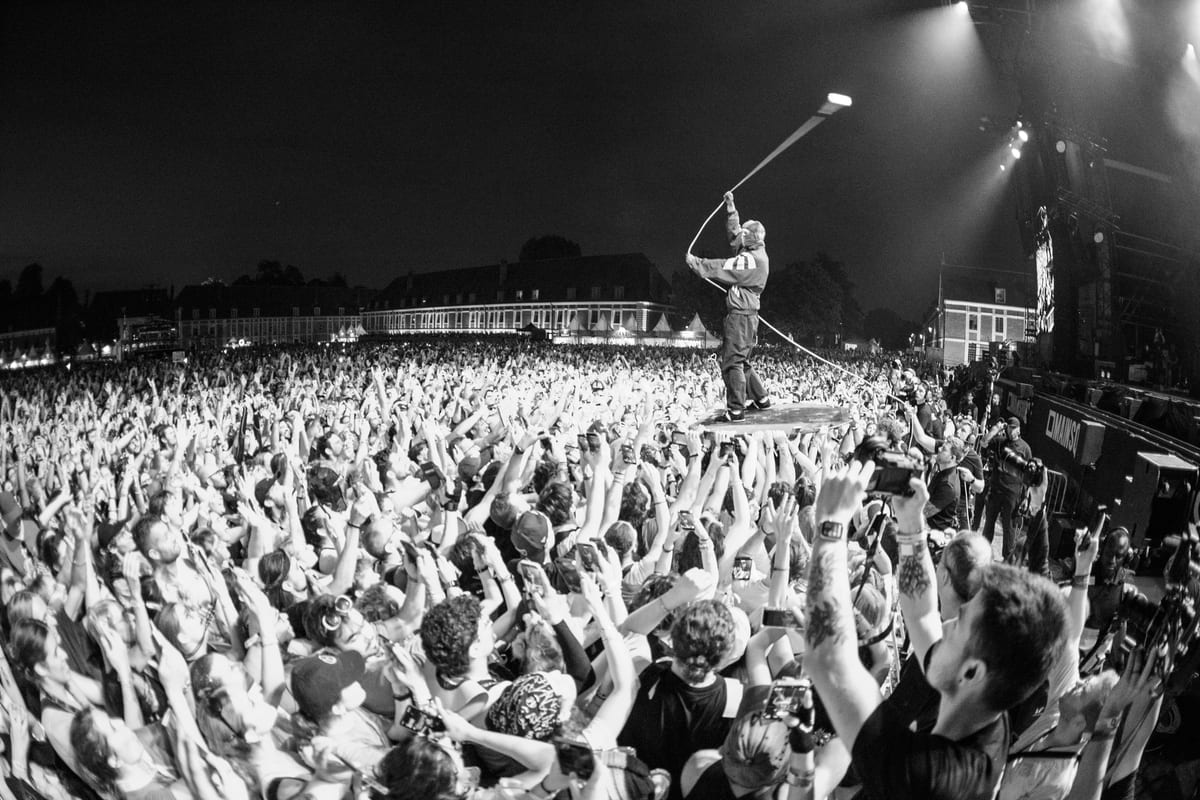 Tyler Joseph de Twenty One Pilots en équilibre sur une plateforme portée par la foule en liesse au Main Square Festival.