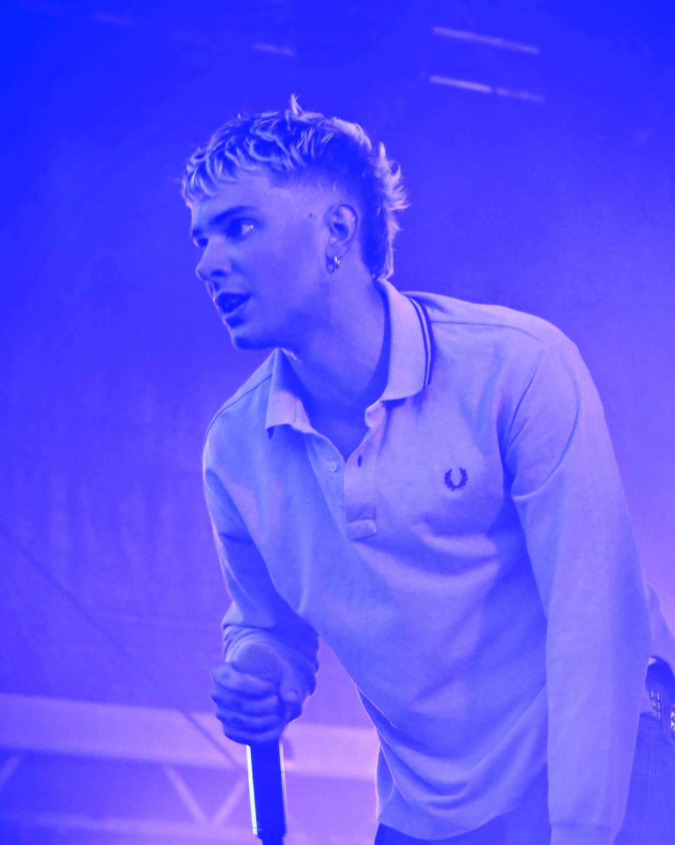Le chanteur de MDNS sous des lumières violettes et des effets de scène.