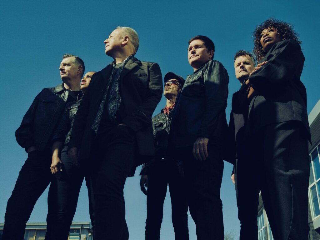 Groupe de simple minds debout regardant devant eux