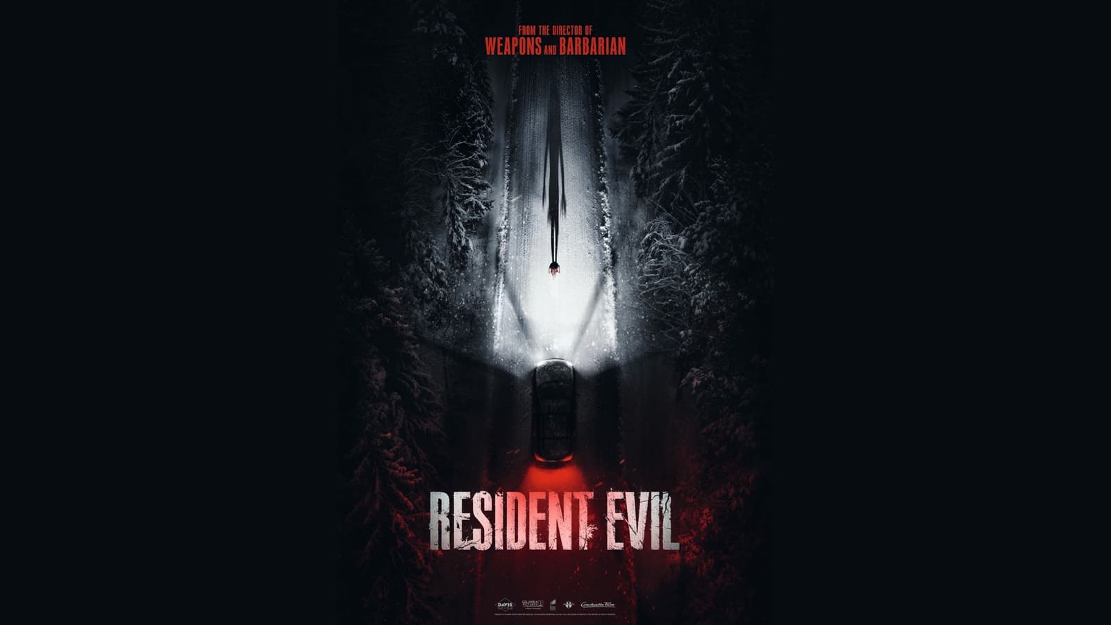 Affiche promotionnelle du film « Resident Evil ». Vue aérienne nocturne d'une voiture sur une route enneigée bordée d'arbres sombres, dont les phares éclairent une silhouette humaine projetant une longue ombre menaçante vers l'avant. En haut, la mention « From the director of Weapons and Barbarian » et en bas, le titre « Resident Evil » en lettres blanches usées.